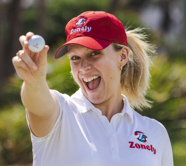 a woman holding a golfball